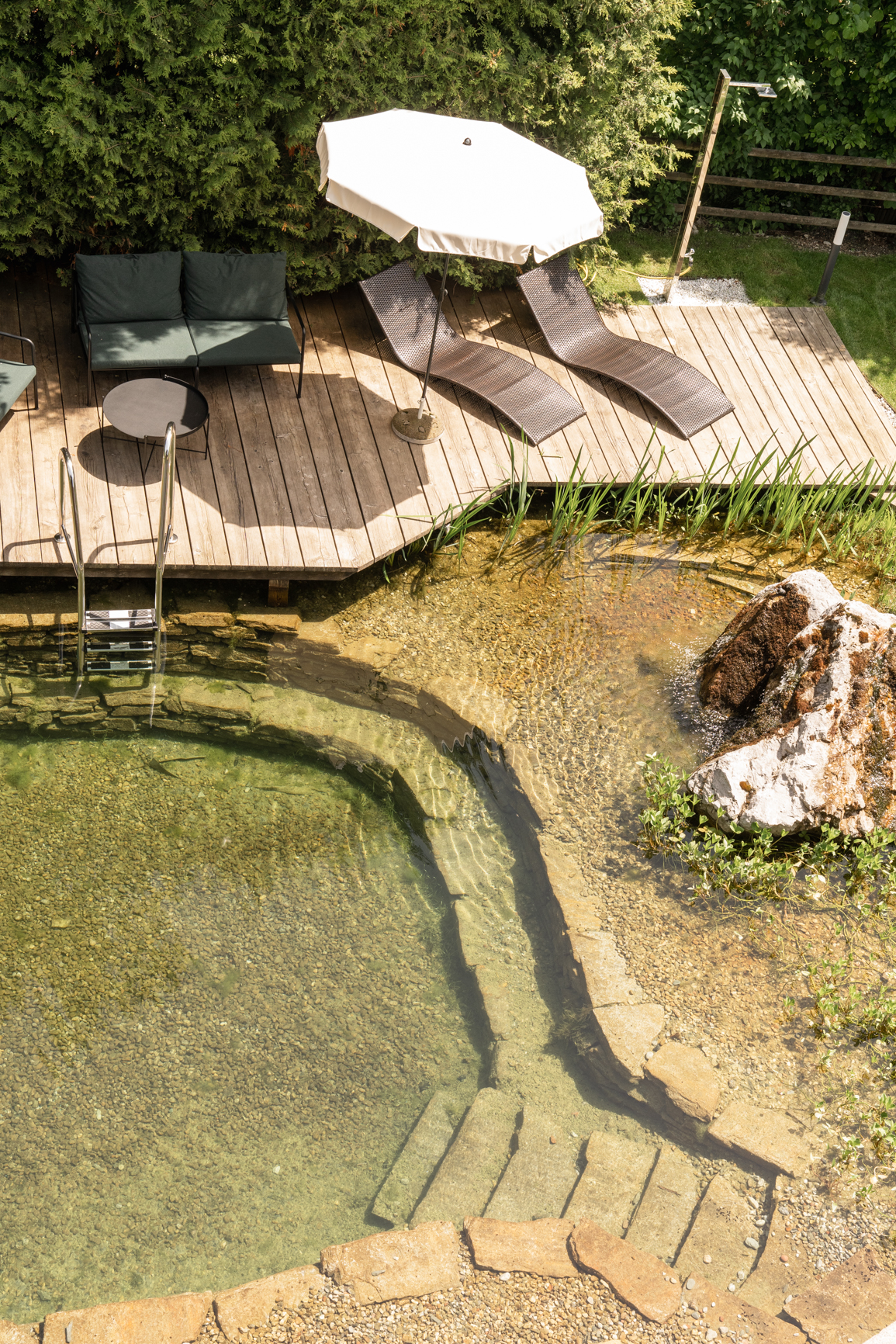 Gartenteich im Sommer bei Sonnenschein mit Blick auf die Berge, Naturbadeteich, Sommerurlaub in den Bergen, Wandern und Wellnessurlaub