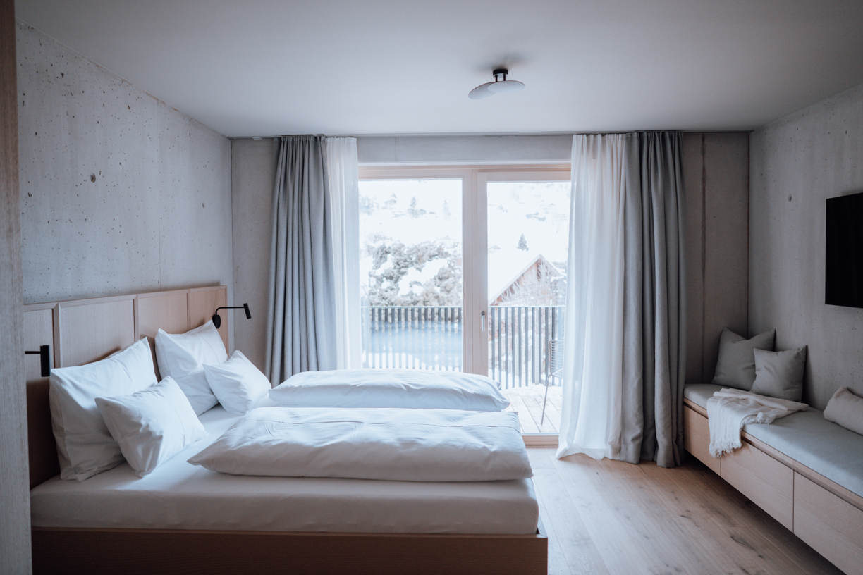 Design Hotelzimmer, Avantgardist und Ästhet, Zimmer mit Ausblick, Kunst, Winterurlaub in den Bergen, Sichtbetonwand, Holz
