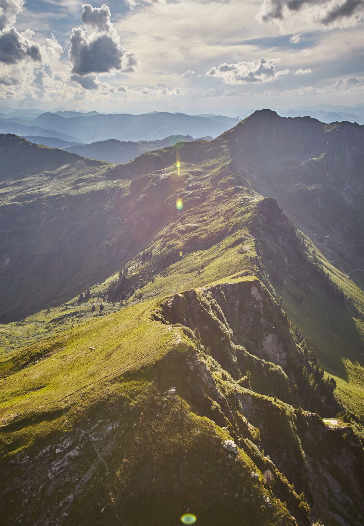 Grüne Bergketten und stimmungsvolle Wolkendecke in der Sommersonne