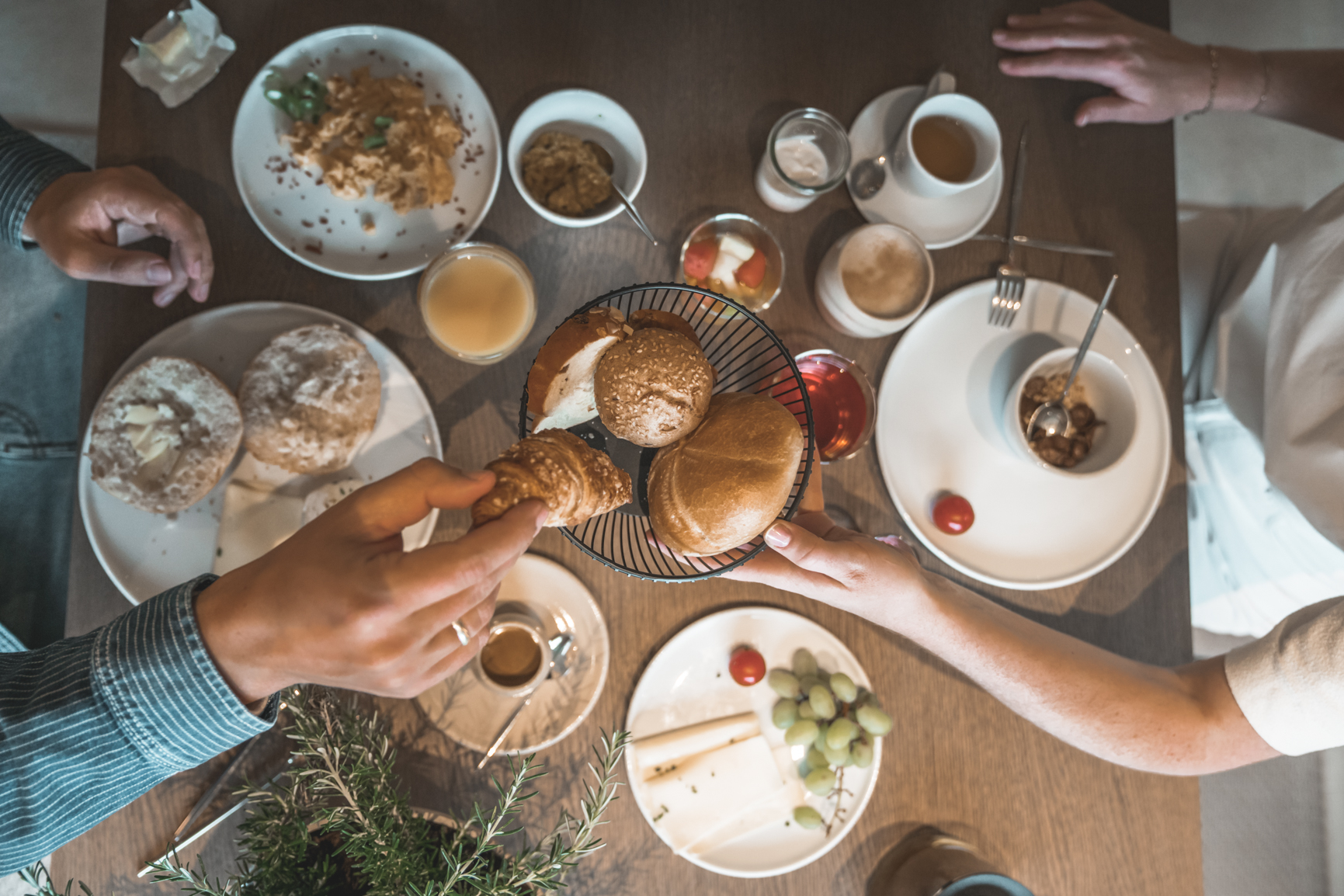 Frühstück mit frischem Brot, Kaffee, Müsli, Fruchtsaft, Marmelade und Obst